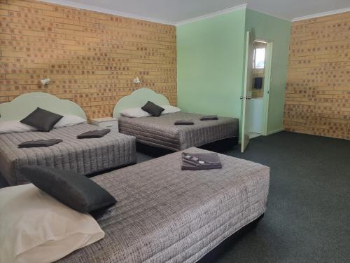 two beds in a hotel room with two beds at Tiaro Motor Inn in Tiaro