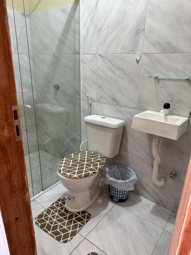 a bathroom with a toilet and a shower and a sink at Pousada encantos de morro branco in Beberibe