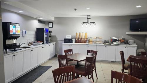 a kitchen with a table and a table and chairs at Travelodge Suites by Wyndham Regina - Eastgate Bay in Regina