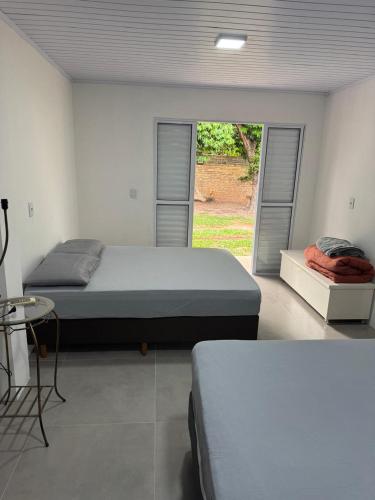 a bedroom with two beds and a window at Pousada da Praça in Rosário do Sul