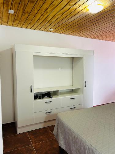 a bedroom with a bed and a white wall at El Floramento in San Pedro de Atacama