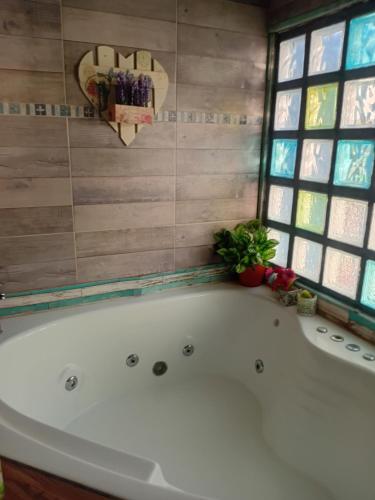 a white bath tub in a bathroom with a window at casa azul in Plottier