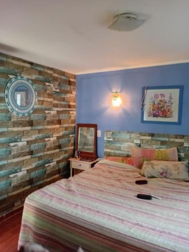 a bedroom with a bed and a brick wall at casa azul in Plottier
