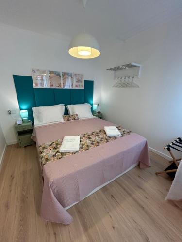 a bedroom with a large bed with a pink bedspread at Dolce Faro Niente Guest House in Faro
