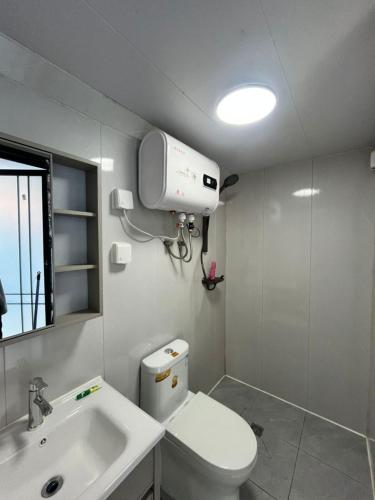 a bathroom with a white toilet and a sink at NeOtel Apartments in Ban Saiyuan (1)