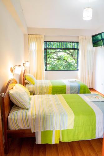 a bedroom with two beds and a window at Valle Hermoso in San Ramón