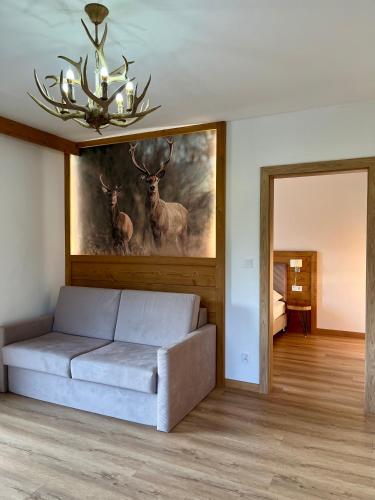 a living room with a couch and a painting of deer at Tatra Widok in Bukowina Tatrzańska