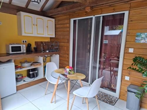 a small kitchen with a table and chairs and a balcony at Gwada fun habitation in Saint-Claude