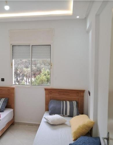 a bedroom with two beds and a window at superbe appartement,vue panoramique,clim,fibre,a3km autoroute in Meknès