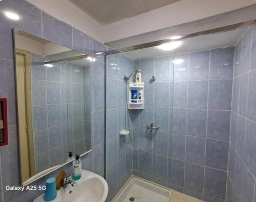 a bathroom with a shower with a sink and a mirror at superbe appartement,vue panoramique,clim,fibre,a3km autoroute in Meknès