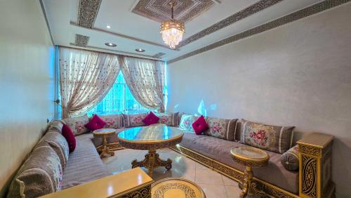 a living room with a couch and a table at Abraj Dubai - Premium 3BR Stay in Heart of Larache in Larache