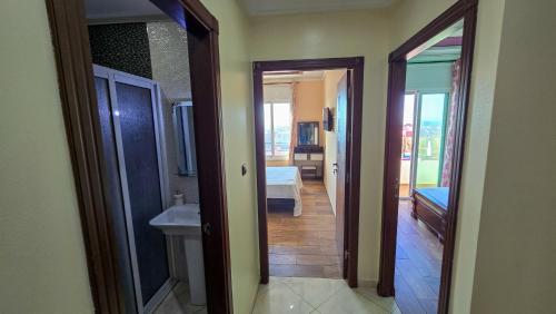a hallway with two doors and a bathroom with a sink at Abraj Dubai - Premium 3BR Stay in Heart of Larache in Larache