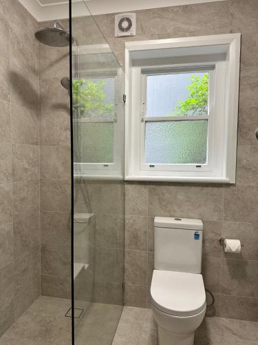 a bathroom with a toilet and a window at Level Access, 2 Mins Walk to Corso, Wharf, Harbour in Sydney