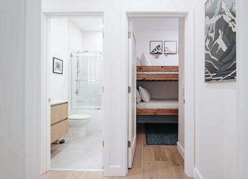 a white bathroom with a shower and a toilet at Cloudscape Penthouse by Revelstoke Vacations in Revelstoke