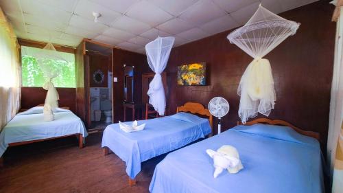 a bedroom with two beds with towels on them at Jacamar Lodge Expeditions in Iquitos