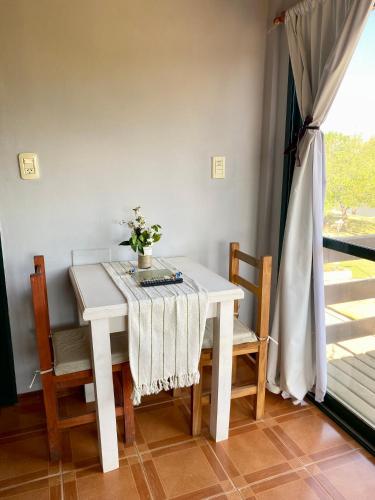 a white table with chairs and a vase of flowers on it at Annemarie Apart in Villa Paranacito