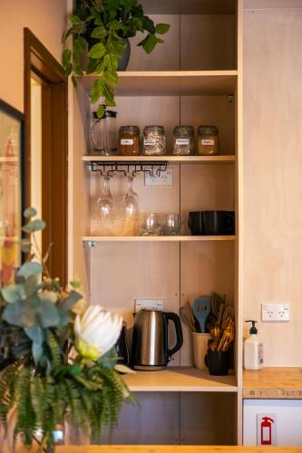 a kitchen shelf with pots and pans on it at Studio C with all you need in Wanaka