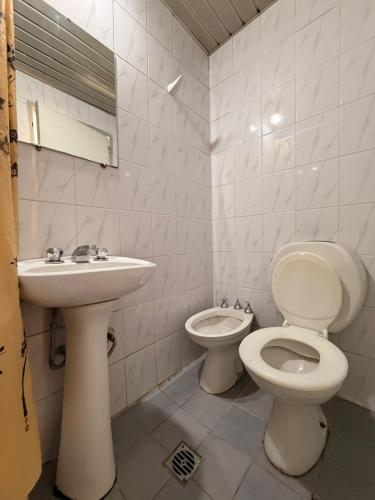 a bathroom with a toilet and a sink at Hotel Aldeano ll in Buenos Aires