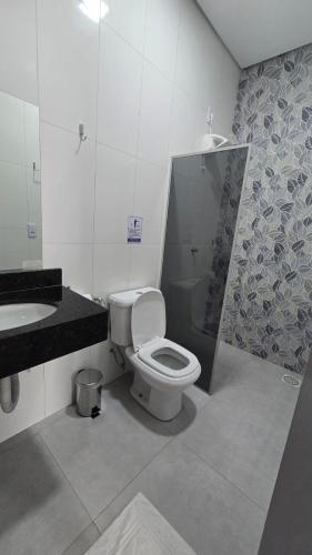 a bathroom with a toilet and a sink at Araguaia Plaza Hotel in Conceição do Araguaia
