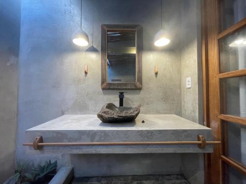 a bathroom with a sink with a rock on it at Pousada Spa Oasis in Caraíva