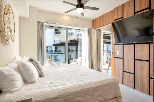 a bedroom with a bed with a ceiling fan and a window at Life Bucerias in Bucerías