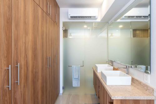 a bathroom with two sinks and a large mirror at Life Bucerias in Bucerías