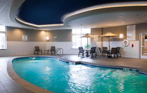 a large swimming pool with chairs and a table at Holiday Inn Express and Suites Madison Central by IHG in Madison