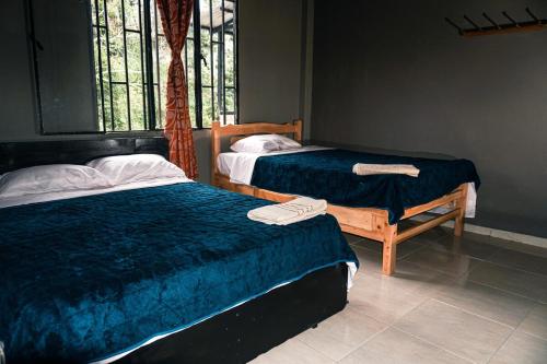 a bedroom with two beds and a window at Casa de Astilla in Mocoa