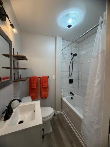 a bathroom with a toilet and a tub and a sink at Friendship Residence in Thunder Bay