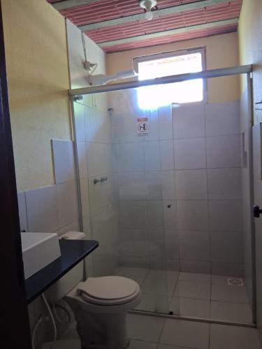 a bathroom with a shower with a toilet and a sink at Pousada Nosso Recanto Camocim in Camocim