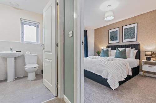 a bedroom with a bed and a sink and a toilet at Spacious 4-Bed Home Near Cribbs & Bristol in Bristol
