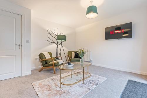 a living room with a table and two chairs at Spacious 4-Bed Home Near Cribbs & Bristol in Bristol