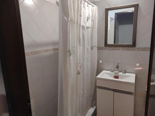 a white bathroom with a sink and a mirror at Lo de Norma in Neuquén