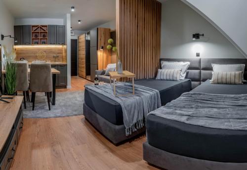 a bedroom with two beds and a dining room at Apart-Hotel Bela Reka in Brzeće
