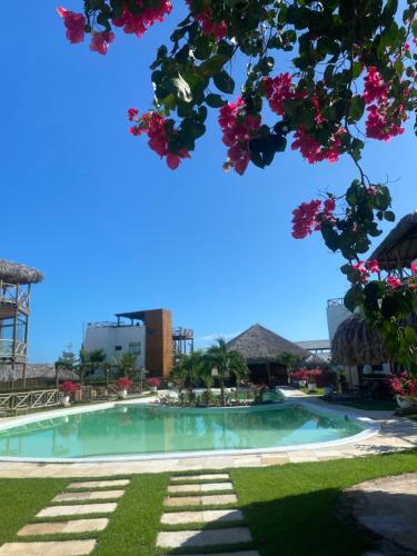 a swimming pool in a resort with pink flowers at Chaleville barrinha in Barrinha