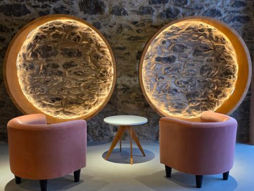 two chairs and a table in front of two large plates at ASPA Studios - Urban Conscious Living in Funchal