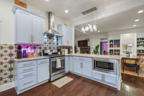 a kitchen with white cabinets and a stove top oven at Stay & Play Indy- Indoor Fun - 5 Min to Downtown - Sleeps 10 - Arcade fun in Indianapolis