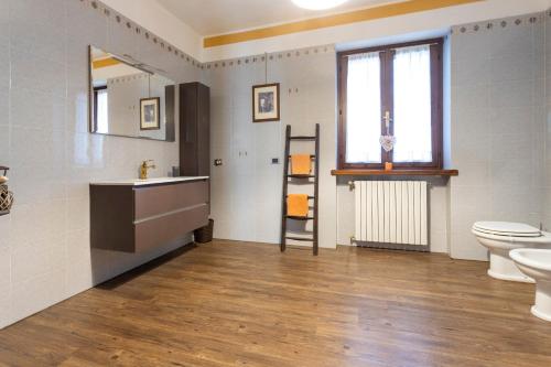 a bathroom with a sink and a toilet and a window at B&B Cascina Baraggione in Granozzo con Monticello