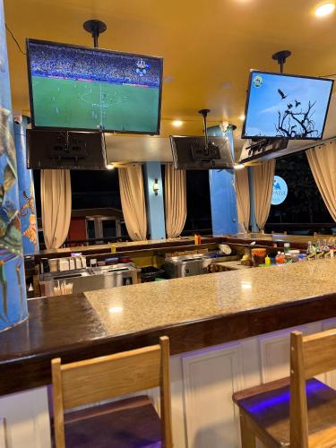 a bar with two monitors on top of it at Hotel Royal Blue & Golf Cart Rental in San Pedro