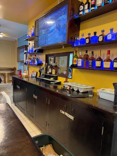 a bar with a television on the wall at Hotel Royal Blue & Golf Cart Rental in San Pedro