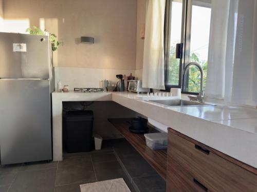 a kitchen with a sink and a refrigerator at Quiet Oceanside Casita Private Kitchen & Bath in Troncones