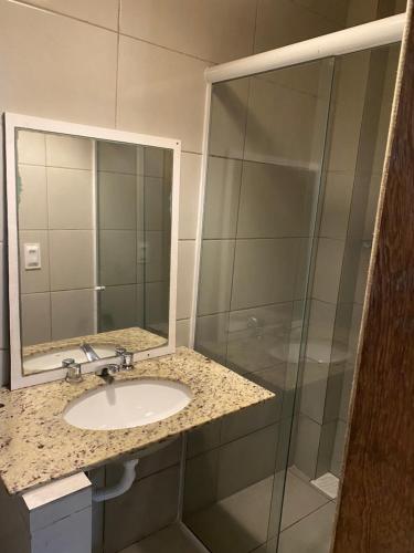 a bathroom with a sink and a shower at InnFloripa - Pousada no Campeche 7 min do Aeroporto in Florianópolis