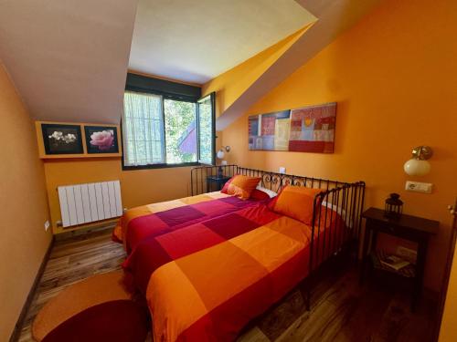 a bedroom with a bed with a colorful blanket at Apartamentos rurales FlordeLinto in La Cárcoba