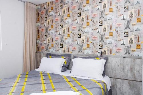 a bedroom with a bed with a wall covered in books at Apartamento sofisticado, confortável e bem equipado - Loft Felau in Cuiabá