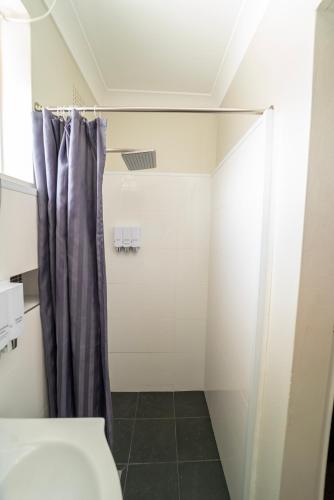 a bathroom with a shower and a shower curtain at Nowra Motor Inn in Nowra