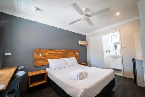 a bedroom with a bed and a ceiling fan at Nowra Motor Inn in Nowra