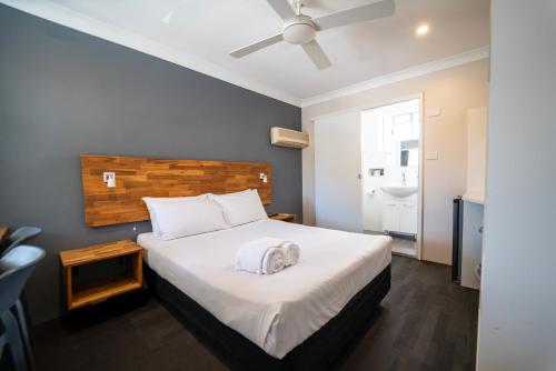 a bedroom with a bed and a ceiling fan at Nowra Motor Inn in Nowra