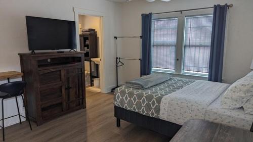 a bedroom with a bed and a flat screen tv at Studio Speedway in Tucson