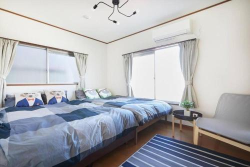 a bedroom with a bed and a chair and windows at Shinjuku area house with 3BR 2mins to Metro on foot in Tokyo
