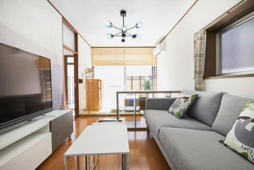 a living room with a couch and a flat screen tv at Shinjuku area house with 3BR 2mins to Metro on foot in Tokyo